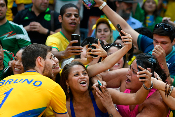 orcida brasileira faz festa e tira foto com Bruninho, do vôlei (Foto: AFP)