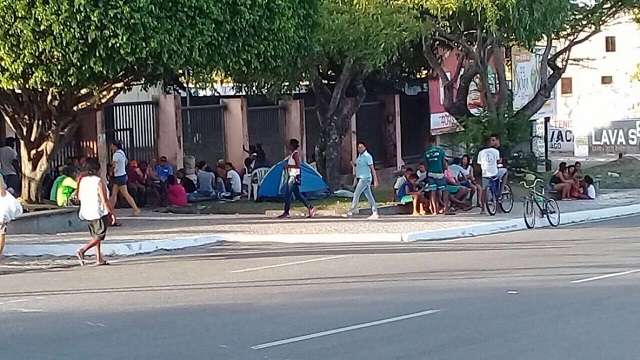 O grupo se aglomerou em frente à escola e passou a noite no local para garantir um lugar na fila e conseguir efetuar a matrícula na escola de preferência (Foto: Camaçari Fatos e Fotos)