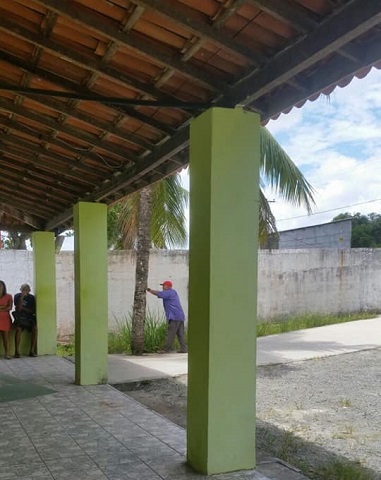 Senhorcom dificuldade de caminhar, para pra descansar bem embaixo do coqueiro