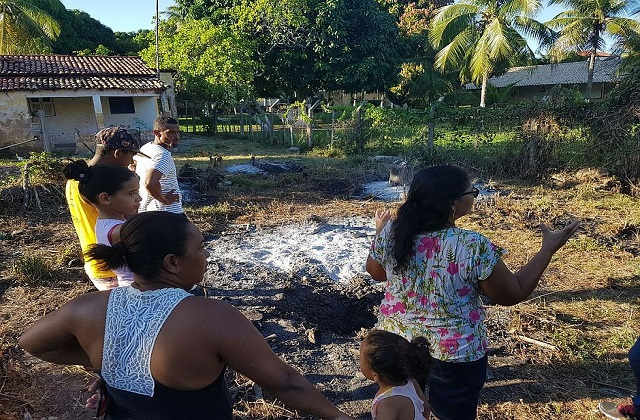 Moradores reunidos em quintal de motorista onde provável meteoro caiu (Raquel Saraiva/CORREIO)
