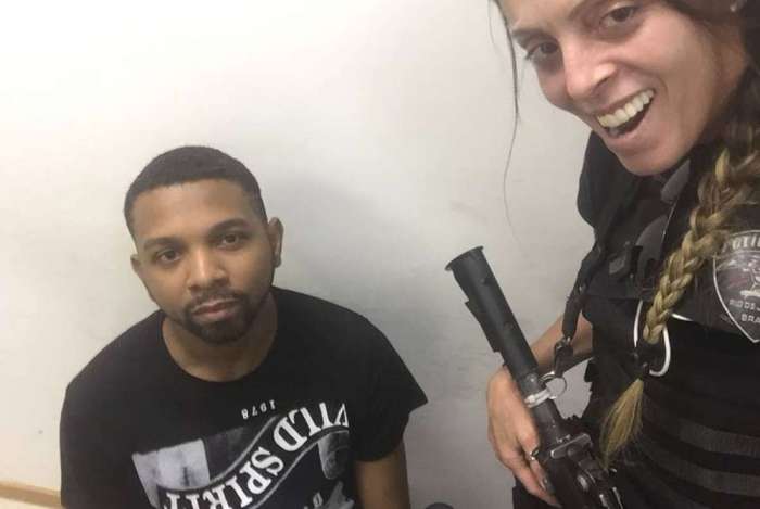 A agente em pose fotográfica com o preso Rogério Avelino da Silva, o Rogério 157