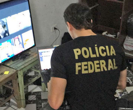 Policial federal analisa computador de suspeito de pornografia infantil em Iguape, SP (Foto: Divulgação | PF)