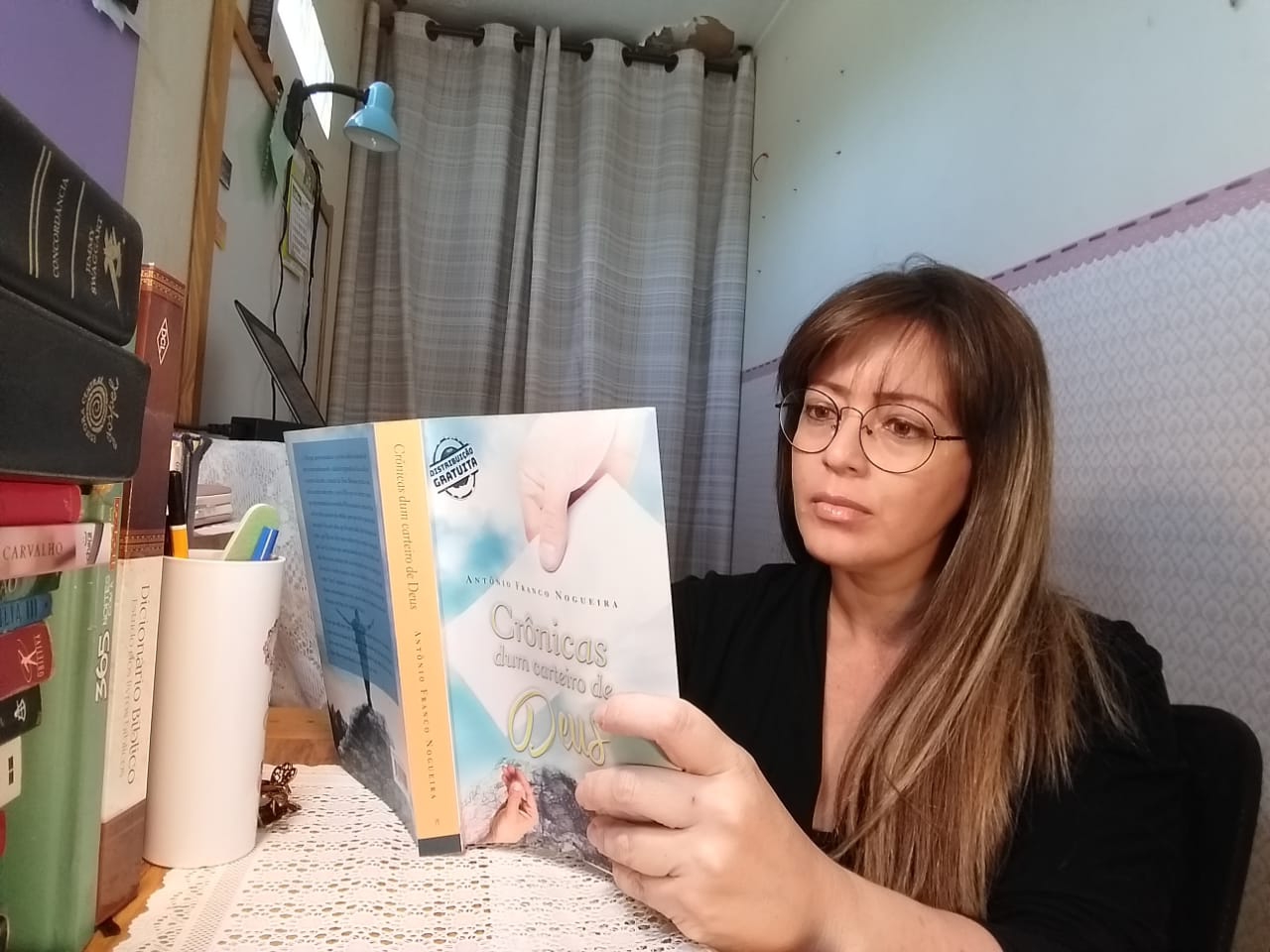 Professora Guena em seu gabinete, lendo o livro que diz a ter encantado pela forma como 'Deus humilha a Ciência arrogante' - Foto: Arquivo pessoal