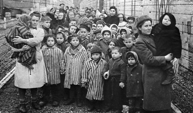 Médicos soviéticos e representantes da Cruz Vermelha são vistos entre prisioneiros do campo de concentração de Auschwitz pouco antes da libertação em 27 de janeiro de 1945 (Foto: Sputnik via AFP) 