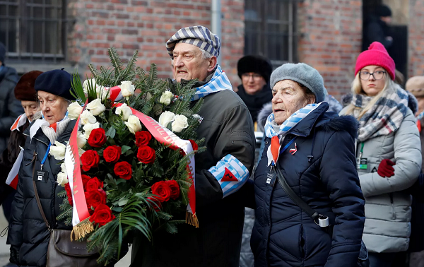 Sobreviventes carregam uma coroa de flores em Auschwitz, na Polônia, nesta segunda-feira (27) (Foto: Aleksandra Szmigiel | Reuters)