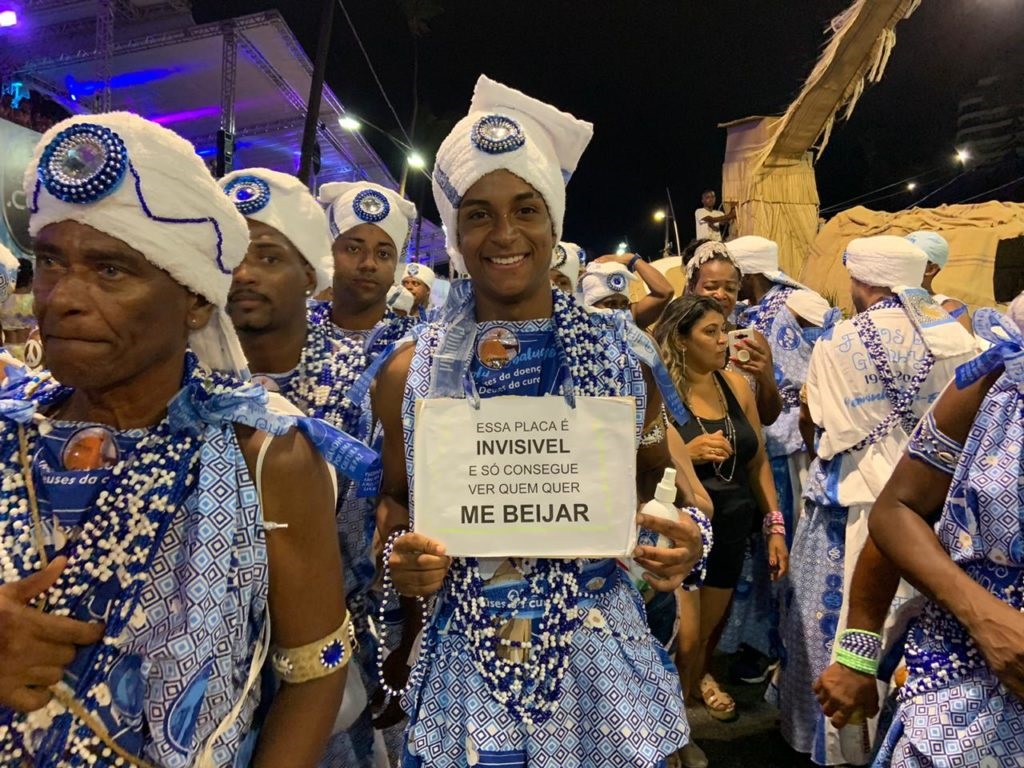 (Além dos colares, o folião investiu numa placa para conseguir mais beijos | Foto: Ananda de Freitas | Ag. A TARDE)