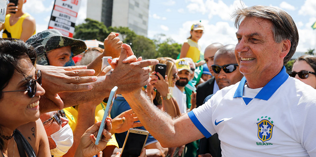 O presidente Jair Bolsonaro cumprimenta os apoiadores que se reuniram em frente ao Palácio do Planalto no domingo, dia 15 de março (Foto: Sergio Lima | AFP)