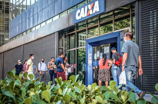 Fila de trabalhadores à porta de agência da Caixa. Pagamento do auxílio-emergencial tem sido conturbado para muitos beneficiários (Foto: Germano Luders | Exame)