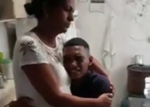 Dona de casa Jucide Oliveira aparece ao lado do filho Jeanderson, que não para de chorar enquanto a mãe narra o que a família passou (Foto: Reprodução)