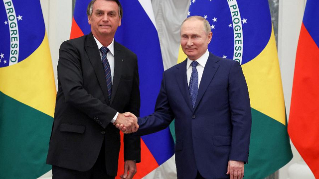 Bolsonaro (à esq.) e Putin apertam as mãos durante visita do brasileiro à Rússia (Foto: SPUTNIK/via REUTERS)