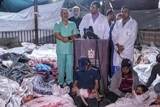 Médicos de Gaza em meio aos corpos de vítimas do bombardeio ao hospital local (Foto: Twitter/Reprodução)